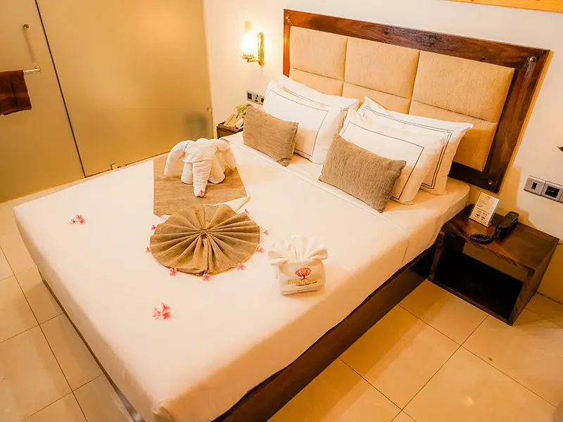 10-day Sri Lanka itinerary for couples: Luxury hotel room prepared for honeymooners with an elephant towel and flower petals on the bed.