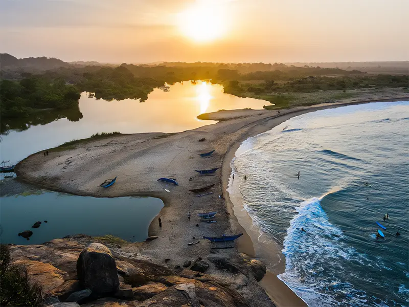Panoramic sunset view from Elephant Rock in Arugam Bay, showing the golden-sand beach, breaking waves, and the adjacent lagoon, a top things to do in Arugam Bay for stunning coastal views.