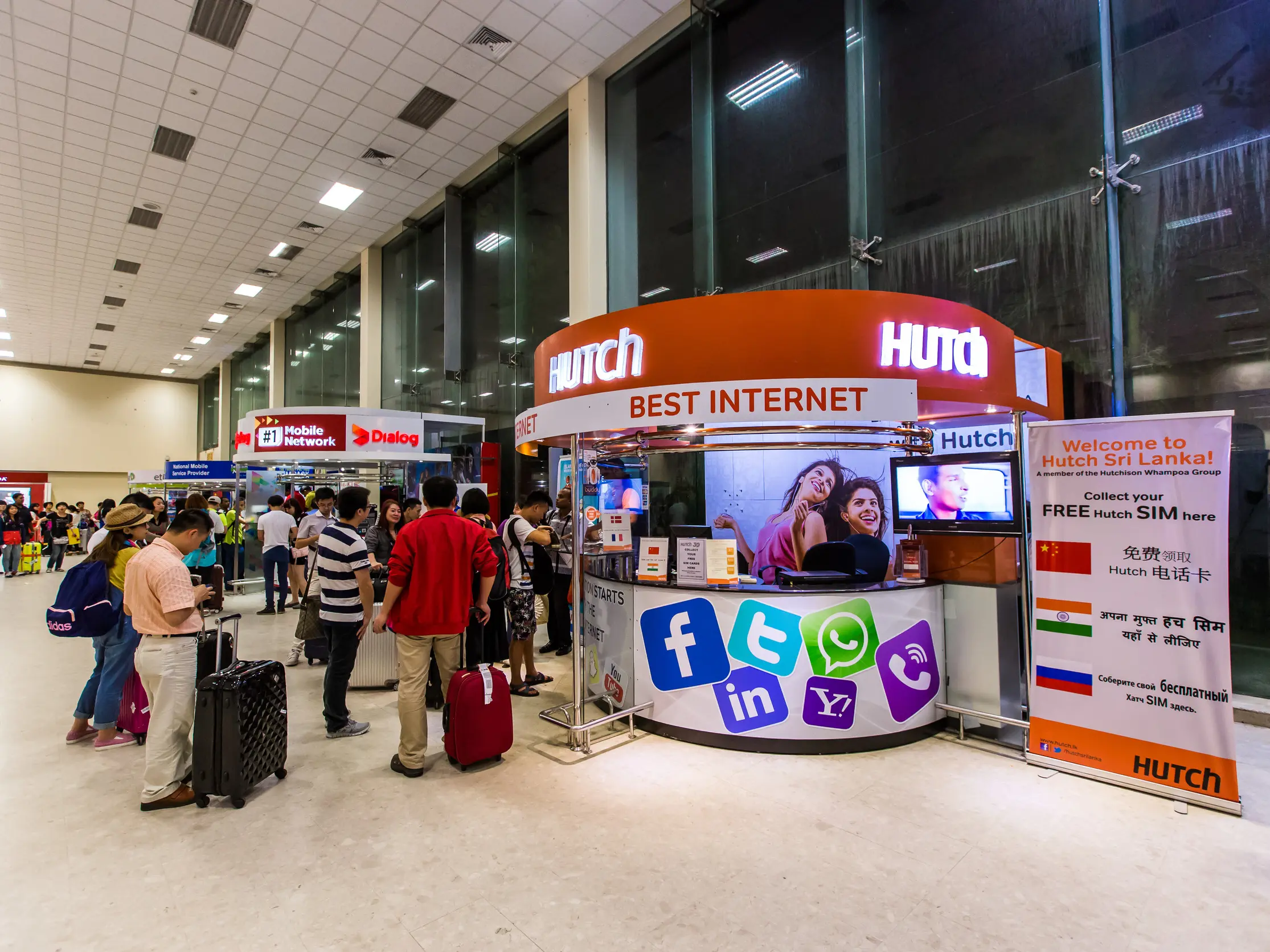 Tourists collecting their best SIM card Sri Lanka tourist package from the Hutch counter at Bandaranaike International Airport (CMB), essential for staying connected during their trip.