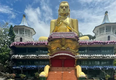 The colossal golden Buddha statue and golden demon mouth entrance of the Dambulla Golden Temple, a key cultural and religious site among things to do in Dambulla