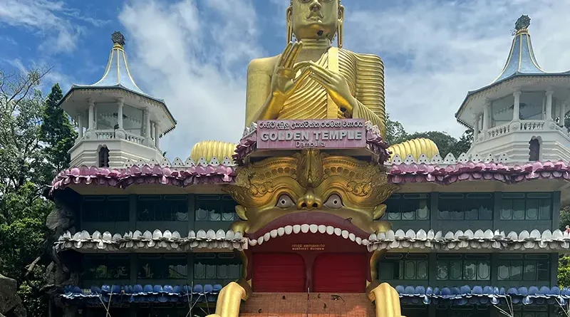 The colossal golden Buddha statue and golden demon mouth entrance of the Dambulla Golden Temple, a key cultural and religious site among things to do in Dambulla