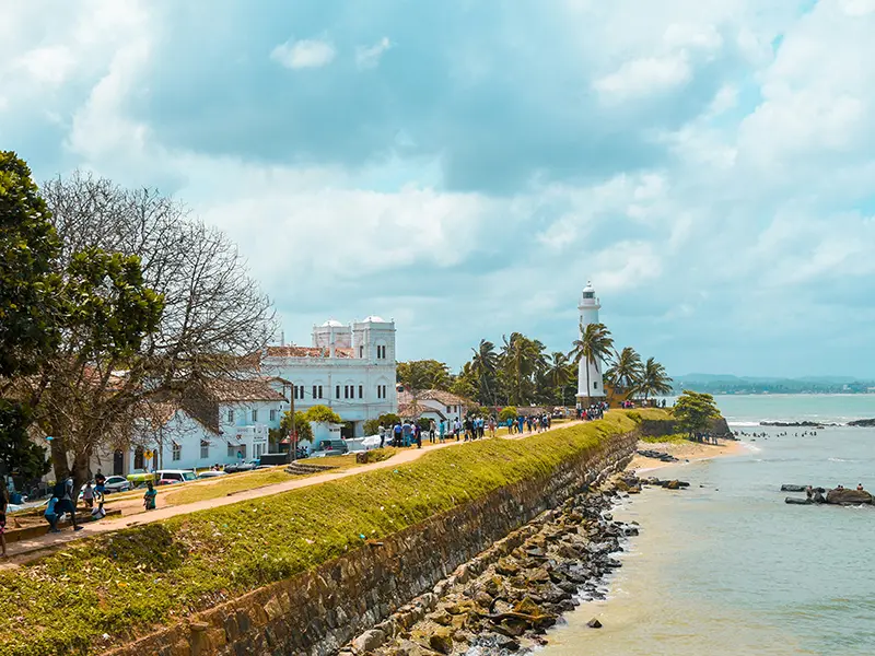 View of the white lighthouse and the historic stone ramparts of Galle Fort, one of the best things to do in Galle Fort for a scenic walk and sunset.