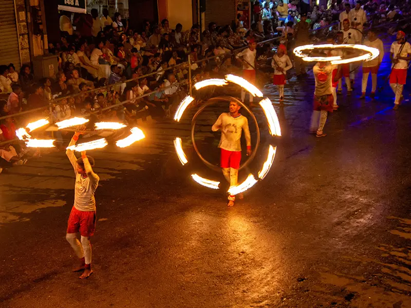 Fire dancers creating rings of light on the street during the spectacular Kandy Esala Perahera night procession.
