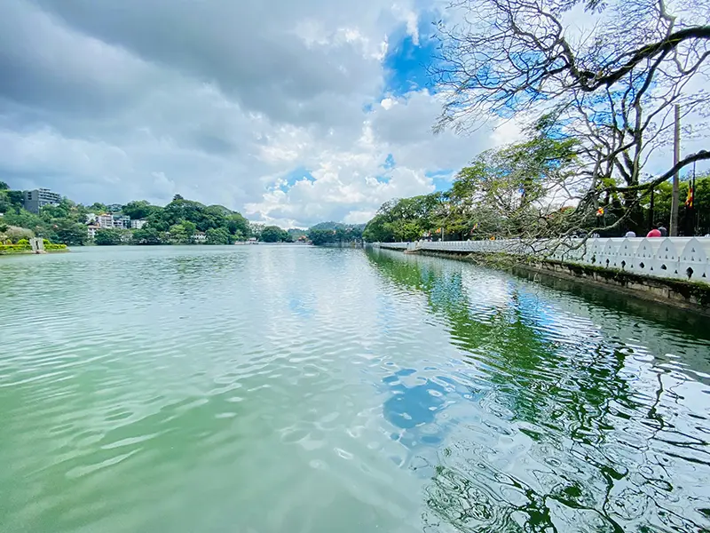 The scenic green waters of Kandy Lake, surrounded by the decorative white wall, a beautiful and relaxing item on the list of things to do in Kandy