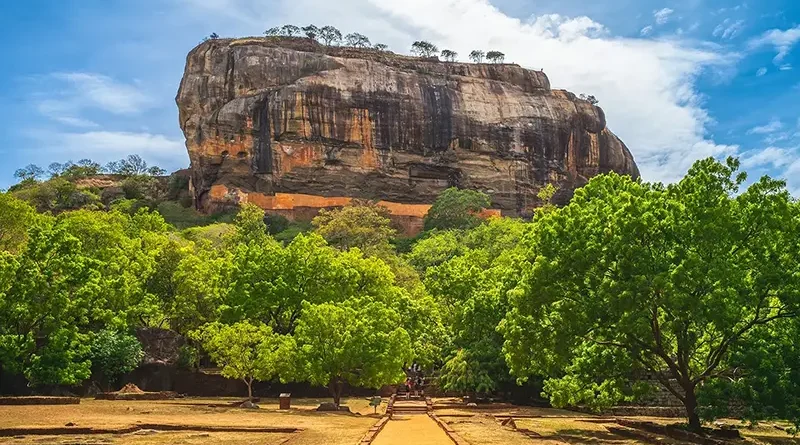 The magnificent Sigiriya Lion Rock Fortress rising above the ancient water gardens, highlighting the climb and historical site, one of the top things to do in Sigiriya.