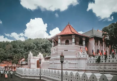 The white exterior of the sacred Temple of the Tooth Relic (Sri Dalada Maligawa) in Kandy under a blue sky, a top cultural item on the list of things to do in Kandy