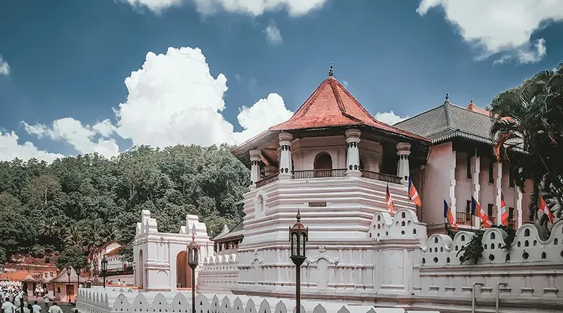The white exterior of the sacred Temple of the Tooth Relic (Sri Dalada Maligawa) in Kandy under a blue sky, a top cultural item on the list of things to do in Kandy
