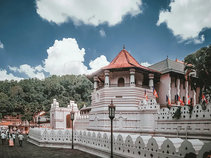 The white exterior of the sacred Temple of the Tooth Relic (Sri Dalada Maligawa) in Kandy under a blue sky, a top cultural item on the list of things to do in Kandy