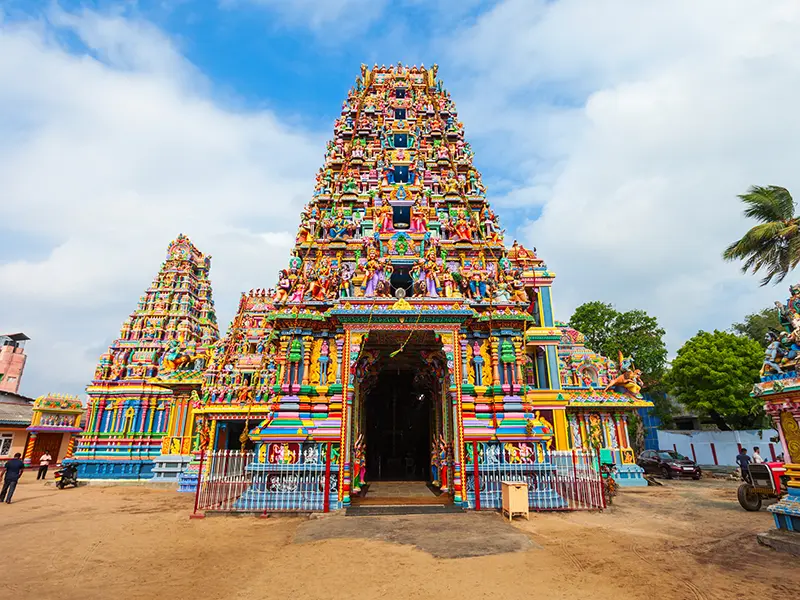 The majestic and vibrant gopuram (tower) of the Pathirakali Amman Temple in Trincomalee, showcasing intricate, colorful sculptures in the classical Dravidian architectural style.